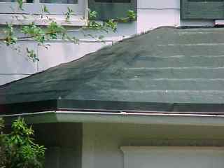 Broader view of capped repaired porch roof