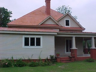 Example of a standing seam or panel roofing used with embossed tin shingles