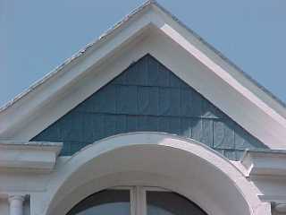 Common touch in embossed tin shingle roofing is use of shingles as siding detail