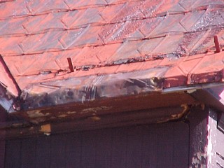 Closeup view of damaged corner of roof