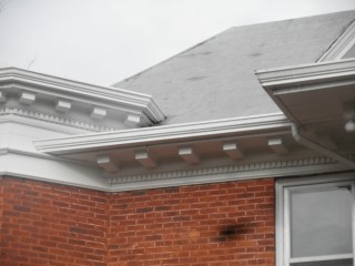 Roof lies flat and ties into roof edge with decorative details and inside gutter